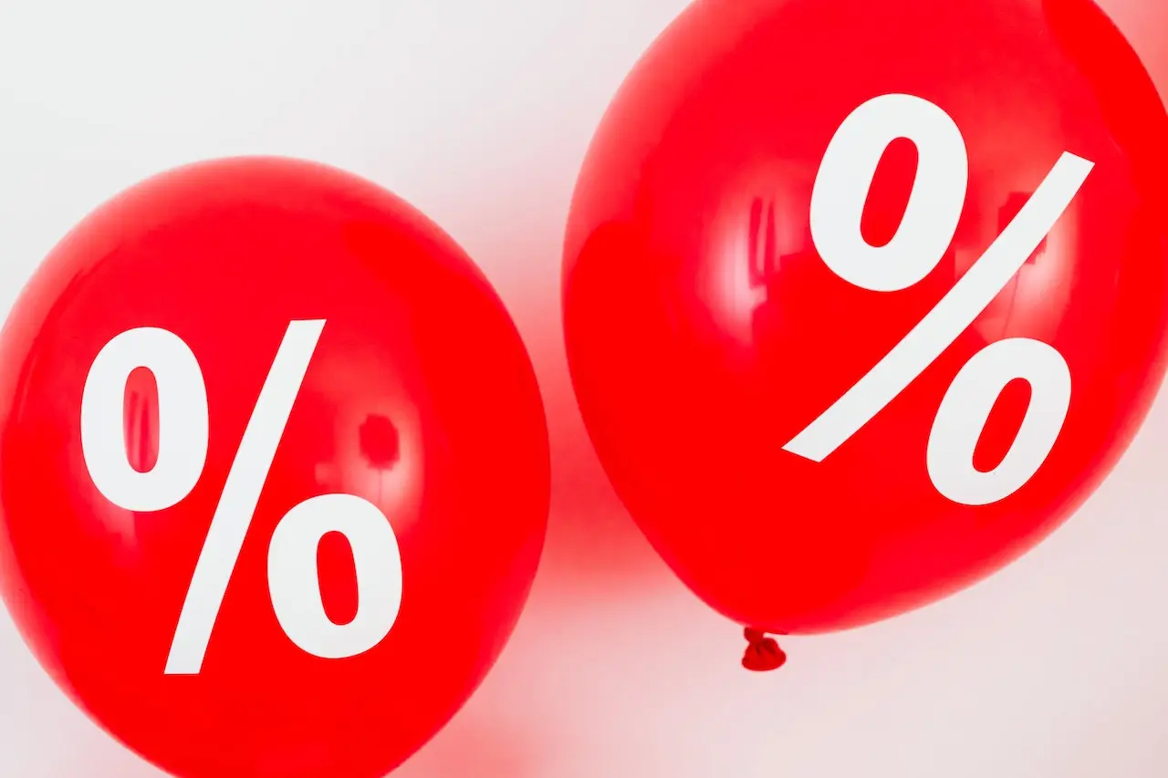 Two red balloons with percentage symbols on them.