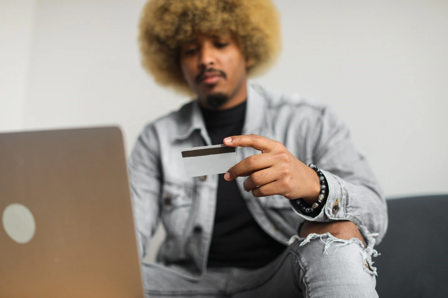 Person entering credit card info into a laptop.