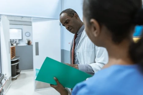 A doctor and nurse looking at a file.