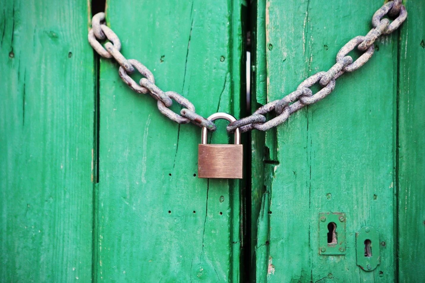 Lock on chain on green door.