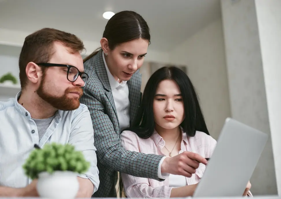 Three people looking at tablet deciding whether to apply for a line of credit or credit card.