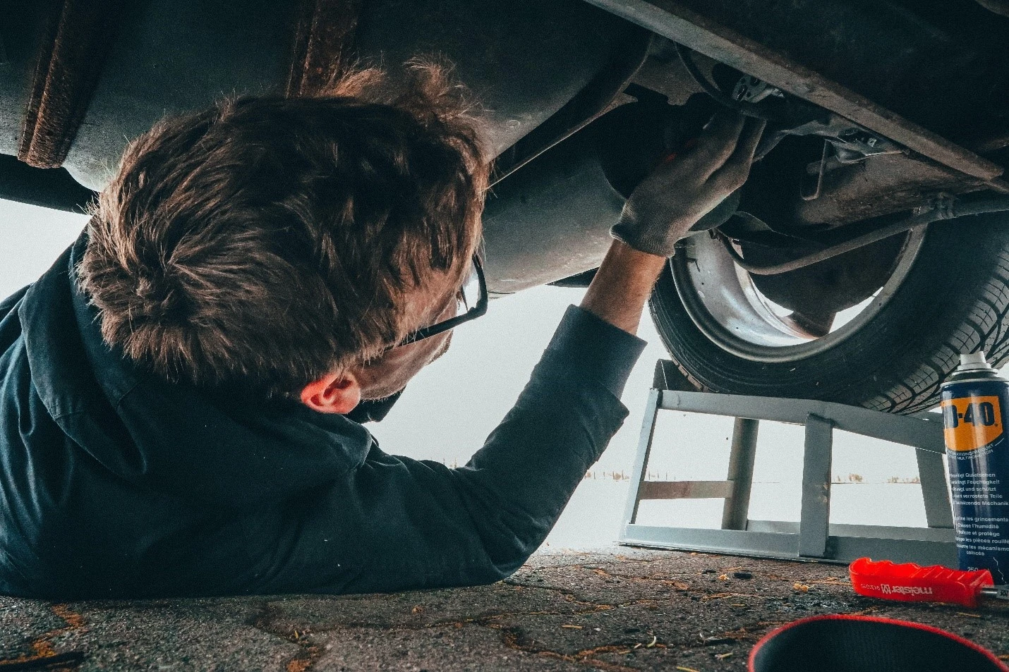 mechanic working underneath car.