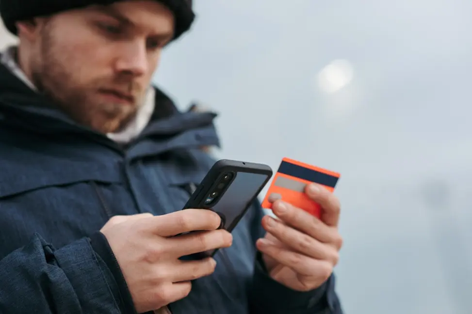 Person entering credit card info into their phone.