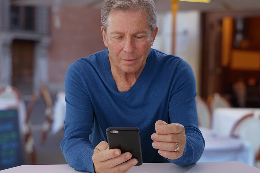 elderly man looking at his phone